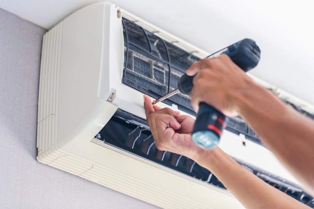 Repairman,Using,A,Screwdriver,Fixing,Modern,Air,Conditioner,,Male,Technician